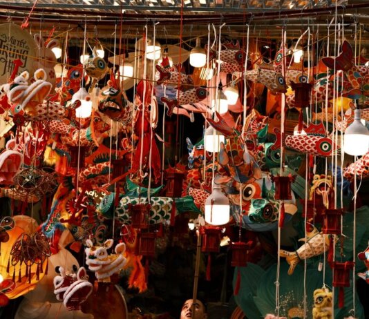 Colorful lanterns and decorations hang tightly in a bustling market for the Mid-Autumn Festival.