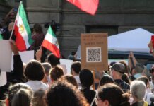 Канада ввела новые санкции против пяти физических лиц и пяти организаций Ирана Crowd demonstrating in Vancouver with Iranian flags advocating for human rights and freedom.