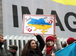 Demonstrators rally for Ukraine in Vancouver, holding signs and flags during a peaceful protest.