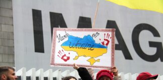 Demonstrators rally for Ukraine in Vancouver, holding signs and flags during a peaceful protest.