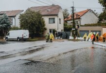 Emergency response team tackles flooding in a residential neighborhood with sandbags and preparation.