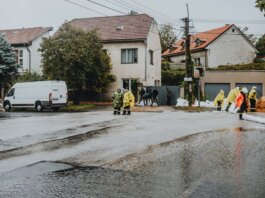 Emergency response team tackles flooding in a residential neighborhood with sandbags and preparation.