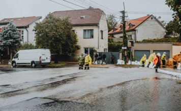 Emergency response team tackles flooding in a residential neighborhood with sandbags and preparation.