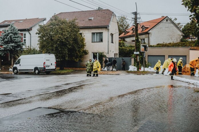 Emergency response team tackles flooding in a residential neighborhood with sandbags and preparation. Emergency response team tackles flooding in a residential neighborhood with sandbags and preparation.