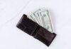 Консерваторы: бездомность в Онтарио выросла на 23% за три года From above of black leather wallet with pockets filled with heap of dollar banknotes on white table