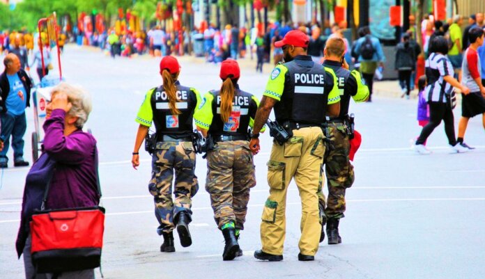 Group of police officers in uniform patrolling a crowded city street on a sunny day. Group of police officers in uniform patrolling a crowded city street on a sunny day.