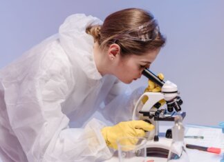 Наука на краю льда: как учёные зафиксировали гибель последнего эпишельфового озера Laboratory scientist in protective gear examining samples with a microscope.