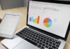 Laptop displaying charts and graphs with tablet calendar for data analysis and planning.
