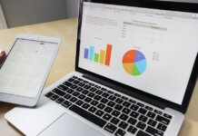Laptop displaying charts and graphs with tablet calendar for data analysis and planning.