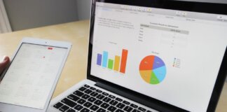 Laptop displaying charts and graphs with tablet calendar for data analysis and planning.