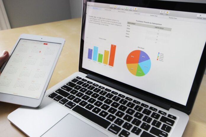Laptop displaying charts and graphs with tablet calendar for data analysis and planning. Laptop displaying charts and graphs with tablet calendar for data analysis and planning.