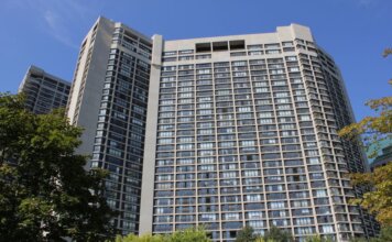 Консерваторы: Карни обещал 500 тысяч домов в год, а стройка падает Modern high-rise residential building in Toronto under clear sky.