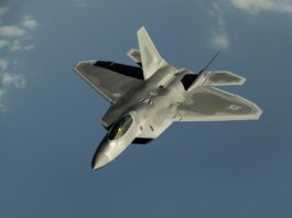 Powerful military aircraft soaring against a calm blue sky.