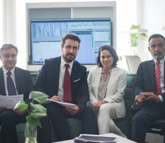 Professional team in corporate attire ready for a meeting, engaged in discussion.