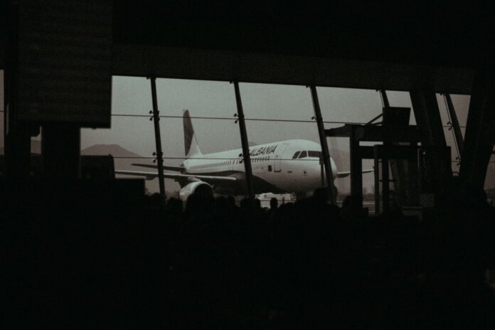 Silhouette of an airplane and waiting passengers inside an airport terminal at dusk. Silhouette of an airplane and waiting passengers inside an airport terminal at dusk.