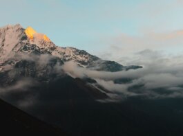 Stunning view of the Himalayan mountains in Nepal during sunrise, with cloud cover adding drama.