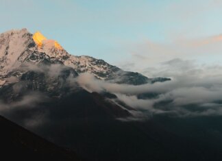 Stunning view of the Himalayan mountains in Nepal during sunrise, with cloud cover adding drama.