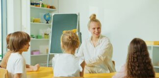 Teacher engaging with preschool children in a colorful classroom setting.