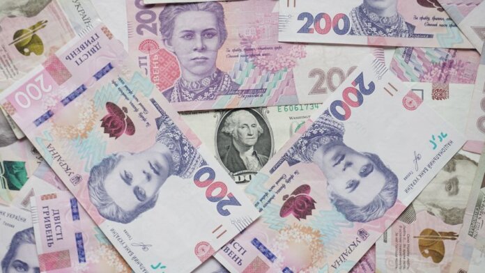 Top view of scattered Ukrainian hryvnia and US dollar banknotes symbolizing wealth. Top view of scattered Ukrainian hryvnia and US dollar banknotes symbolizing wealth.