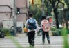 Полиция Гамильтона напоминает о безопасности в начале учебного года Two children with backpacks crossing a street at a pedestrian crossing.