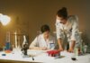 Two scientists working in a laboratory conducting experiments with various equipment and samples.