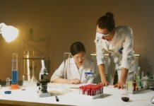 Учёные UBC выяснили, почему болезнь Хантингтона у части пациентов начинается на 10 лет раньше Two scientists working in a laboratory conducting experiments with various equipment and samples.