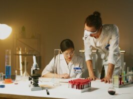 Two scientists working in a laboratory conducting experiments with various equipment and samples.