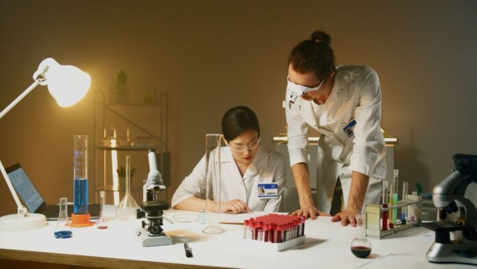Two scientists working in a laboratory conducting experiments with various equipment and samples. Two scientists working in a laboratory conducting experiments with various equipment and samples.