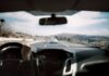 Полиция Калгари ищет записи видеорегистраторов после аварии на Deerfoot Trail View from a car driving down a scenic highway with hills in the background, depicting a casual road trip.