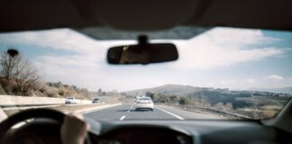 View from a car driving down a scenic highway with hills in the background, depicting a casual road trip.