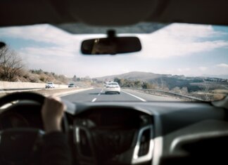 Полиция Калгари ищет записи видеорегистраторов после аварии на Deerfoot Trail View from a car driving down a scenic highway with hills in the background, depicting a casual road trip.