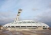 View of the iconic Olympic Stadium in Montreal, Canada, under a cloudy sky.