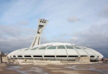 View of the iconic Olympic Stadium in Montreal, Canada, under a cloudy sky.
