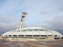View of the iconic Olympic Stadium in Montreal, Canada, under a cloudy sky.
