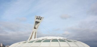 View of the iconic Olympic Stadium in Montreal, Canada, under a cloudy sky.