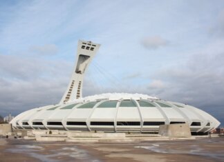 View of the iconic Olympic Stadium in Montreal, Canada, under a cloudy sky.