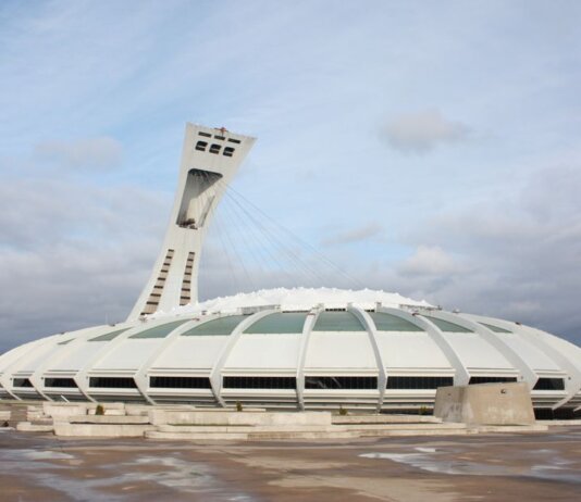 View of the iconic Olympic Stadium in Montreal, Canada, under a cloudy sky.