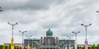 View of the Perdana Putra building, a landmark of Malaysian architecture, from a street perspective.