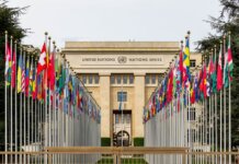 View of the United Nations Office in Geneva adorned with flags of various countries.