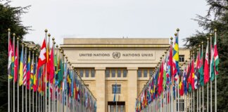 View of the United Nations Office in Geneva adorned with flags of various countries.