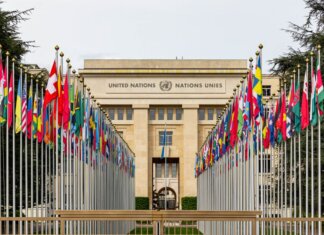 View of the United Nations Office in Geneva adorned with flags of various countries.