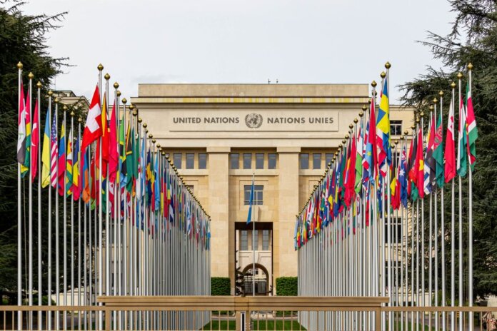 View of the United Nations Office in Geneva adorned with flags of various countries. View of the United Nations Office in Geneva adorned with flags of various countries.