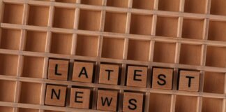 Wooden letter blocks spelling Latest News on a grid background, ideal for media themes.