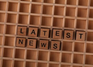 Пропавший канадец найден живым после наводнения в Непале Wooden letter blocks spelling Latest News on a grid background, ideal for media themes.
