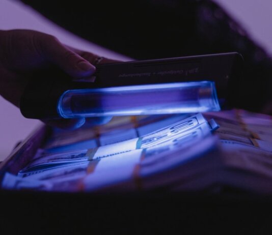 A close-up shot of banknotes under UV light to verify currency authenticity and detect counterfeits.