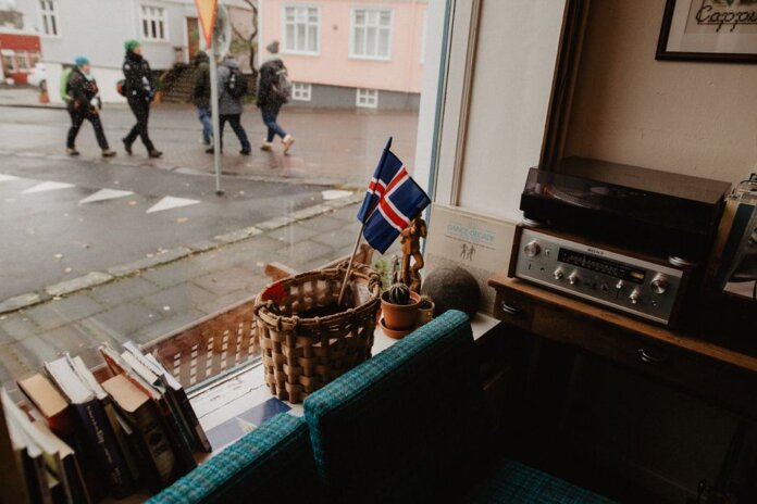 A cozy corner in a Reykjavik café featuring Icelandic decor and a view of the city street. A cozy corner in a Reykjavik café featuring Icelandic decor and a view of the city street.