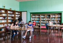 Студенты Western создают детские книги о здоровье, в которых ребёнок узнает себя A diverse group of kids reading books in a library setting, fostering learning and togetherness.