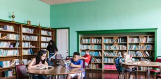 A diverse group of kids reading books in a library setting, fostering learning and togetherness.