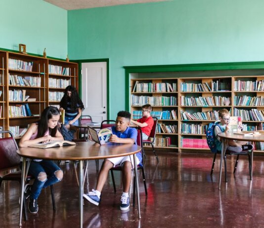 A diverse group of kids reading books in a library setting, fostering learning and togetherness.