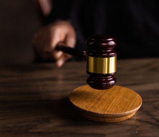 A gavel striking a sound block, symbolizing justice and legal authority in a courtroom setting.